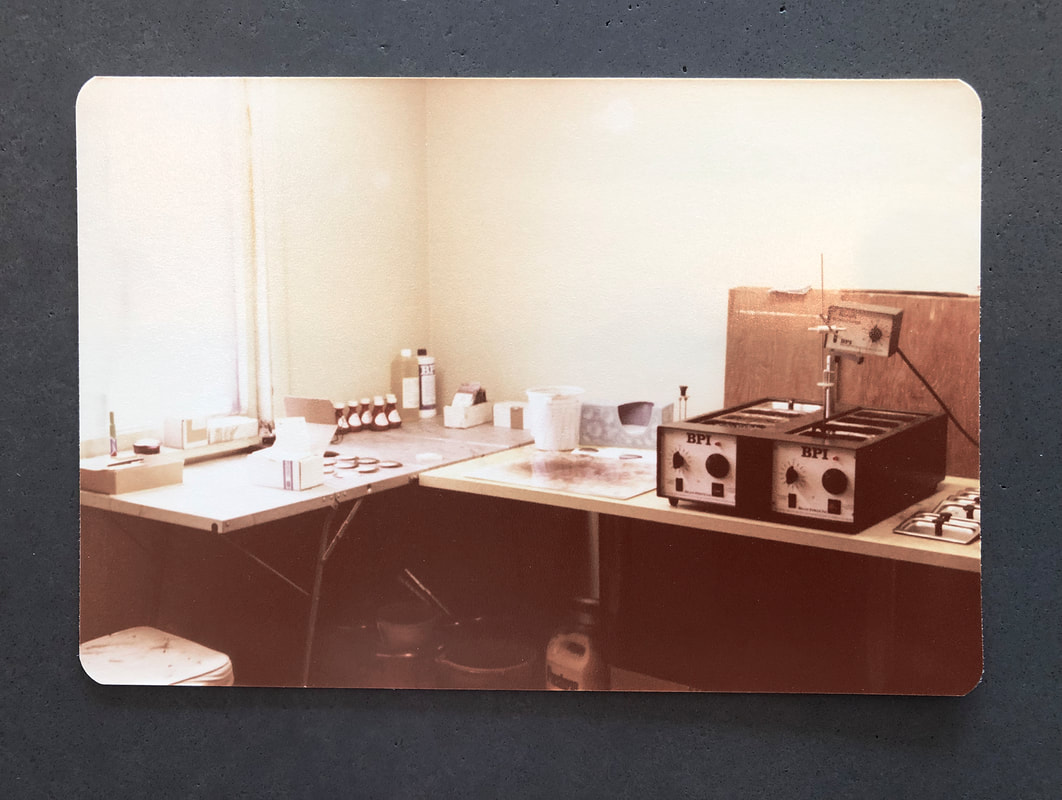 The original 1977 Fashion Tints lens-tinting workbench with BPI tinting machines, an archival photograph.
